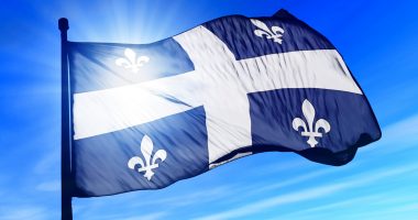 Quebec flag against the backdrop of a blue sky