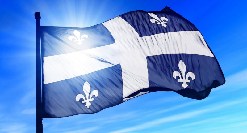 Quebec flag against the backdrop of a blue sky