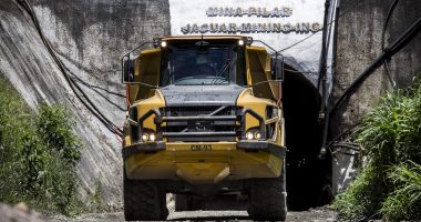 A large mining truck driving out of a tunnel.