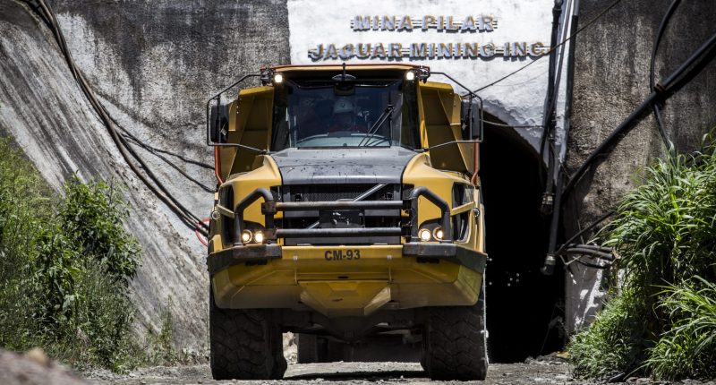 A large mining truck driving out of a tunnel.