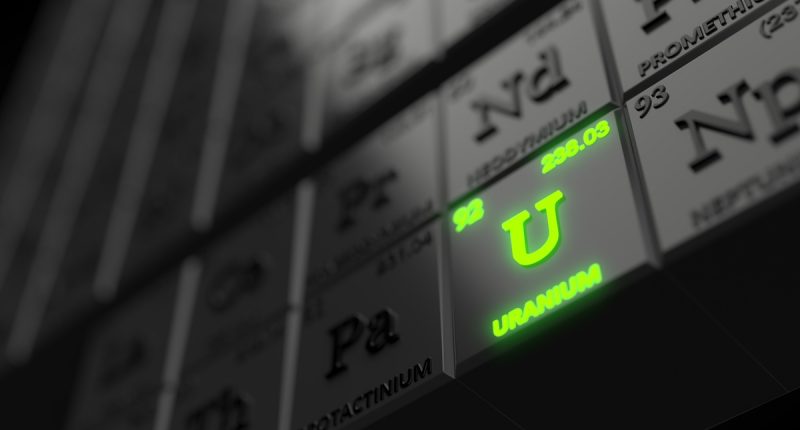 Periodic table concept with uranium element is glowing among black cubes