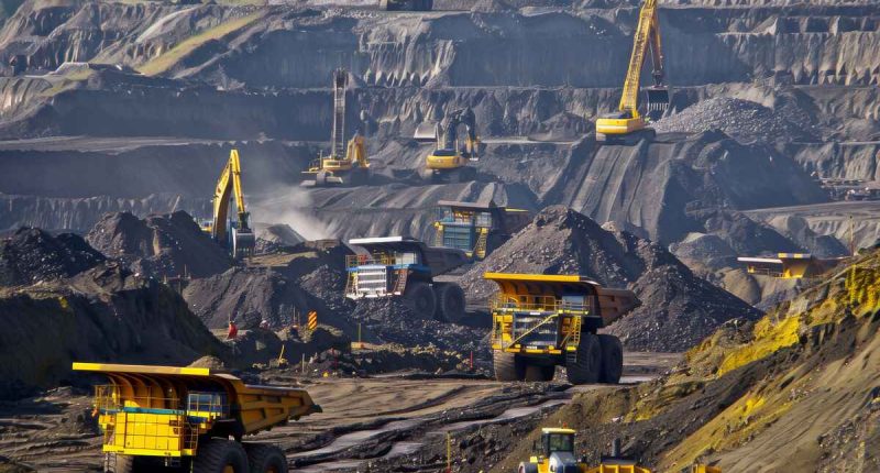 Trucks and excavators at work in an open pit gold mine.