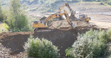 Bulldozers building dams at a mine site.