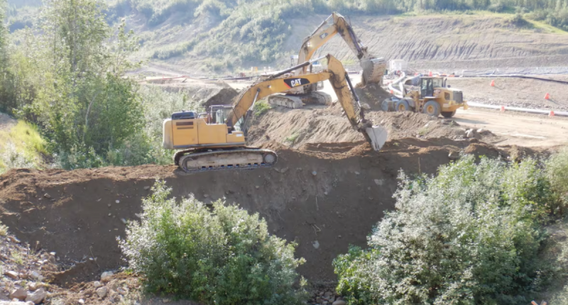 Bulldozers building dams at a mine site.