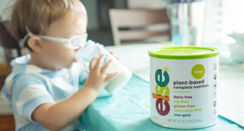 A toddler drinking a nutritional beverage.