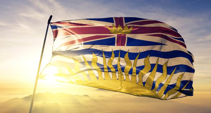 British Columbia province flag waving on top of a sunrise