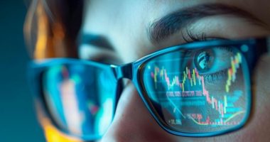 Stock chart reflected in woman's eyeglasses