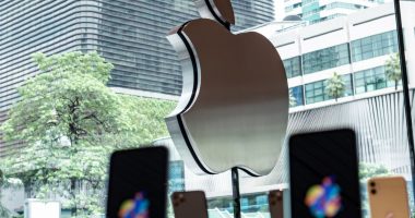 Apple logo on Apple Store with iPhones in the foreground.