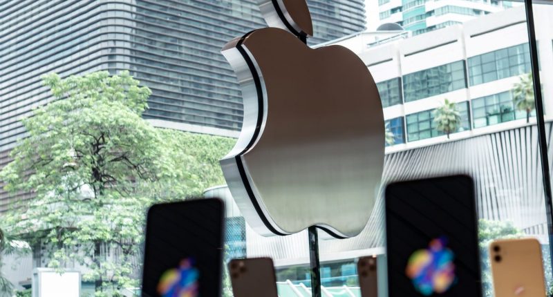 Apple logo on Apple Store with iPhones in the foreground.