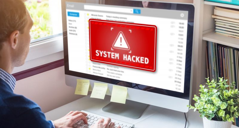 System hacked alert on computer screen after cyber attack on network.