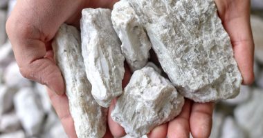 Hands holding hard rock spodumene ore, a commercially important source of lithium.