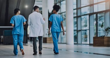 Healthcare workers walking in a hospital.