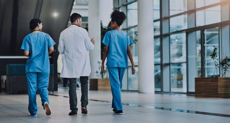 Healthcare workers walking in a hospital.