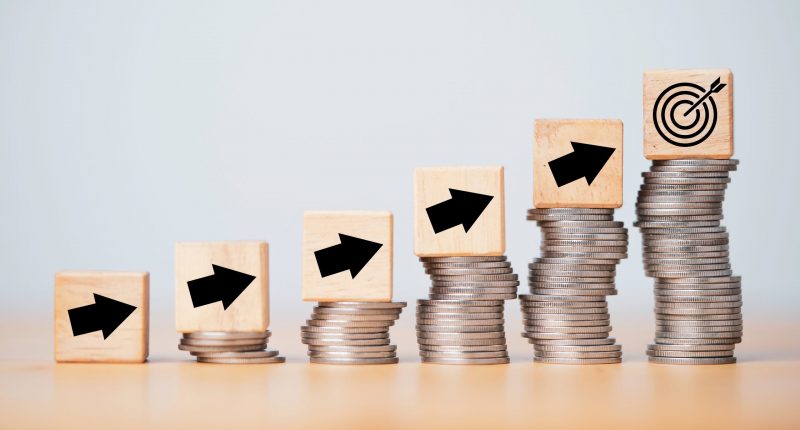 Wooden arrows on coins in an upward pattern